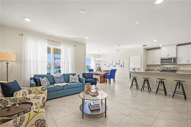 living room featuring light tile floors and a chandelier