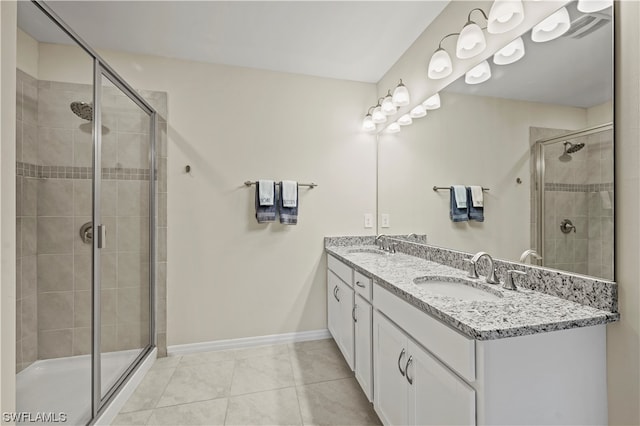 bathroom featuring a shower with shower door, double sink, large vanity, and tile flooring