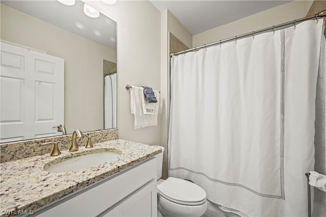 bathroom with vanity with extensive cabinet space and toilet