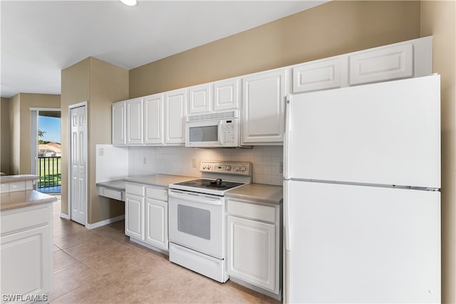 kitchen featuring backsplash, white appliances, light tile flooring, and white cabinetry