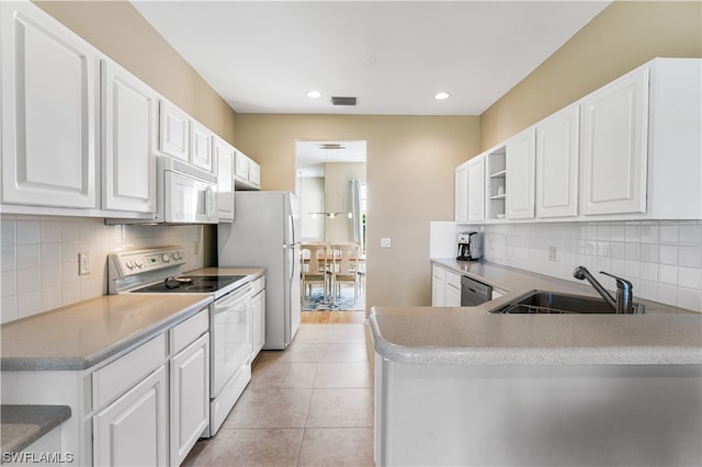 kitchen featuring white appliances, sink, light tile floors, white cabinets, and tasteful backsplash