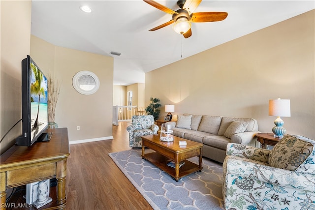 living room featuring ceiling fan and dark hardwood / wood-style flooring