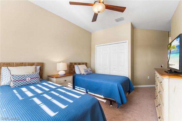 carpeted bedroom with a closet, ceiling fan, and vaulted ceiling