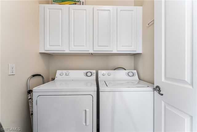 washroom featuring cabinets and separate washer and dryer