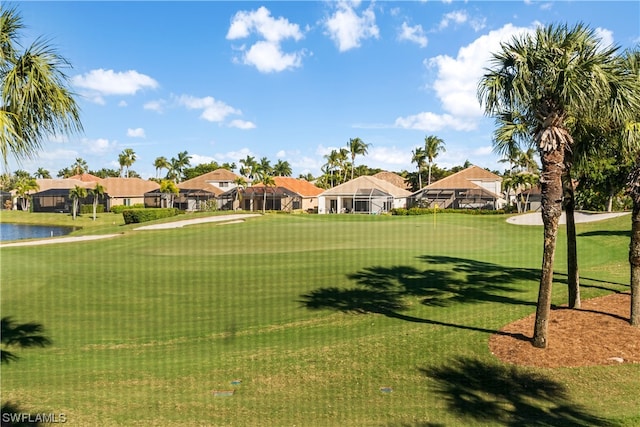 surrounding community with a water view and a lawn