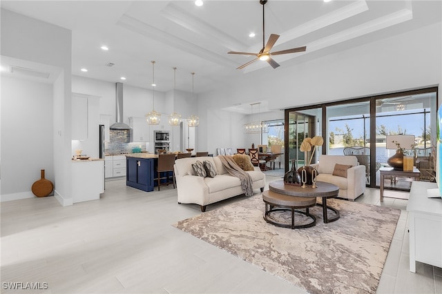 living room with a raised ceiling and ceiling fan