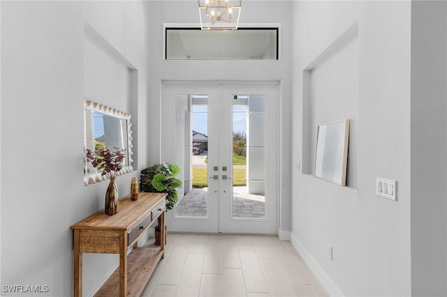 doorway to outside featuring french doors and a notable chandelier