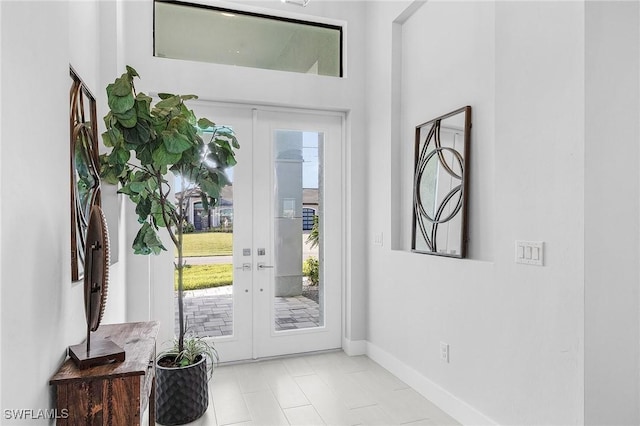 foyer entrance featuring french doors, light tile patterned floors, and a healthy amount of sunlight