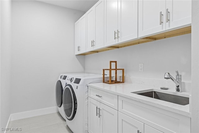 laundry area with washer and clothes dryer, sink, and cabinets