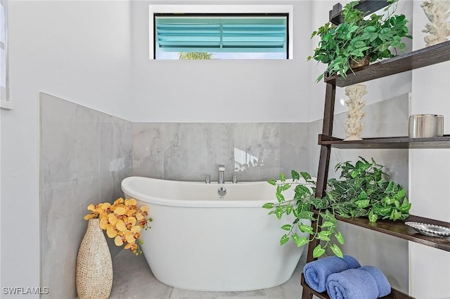 bathroom featuring tile walls and a tub