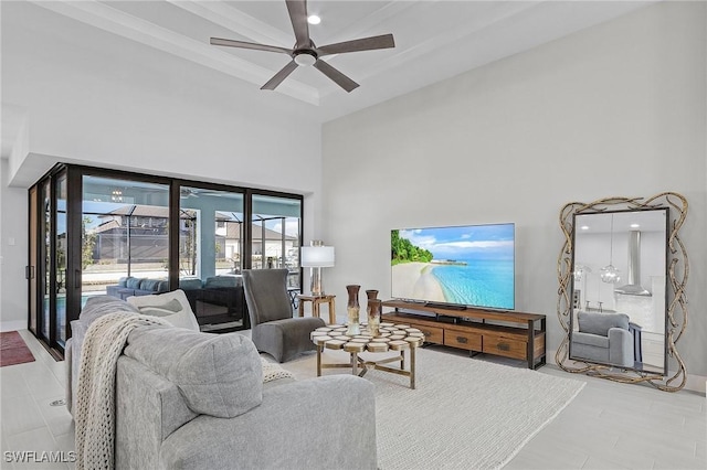 living room with ceiling fan and a high ceiling