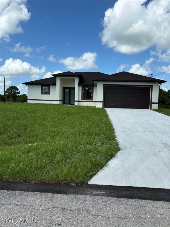 view of front of property featuring a front yard and a garage