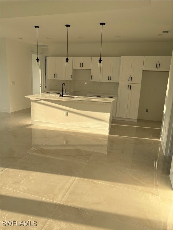 kitchen featuring sink, white cabinets, pendant lighting, and a kitchen island