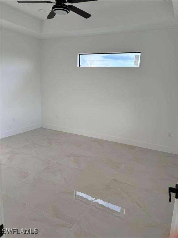 spare room featuring ceiling fan and a tray ceiling