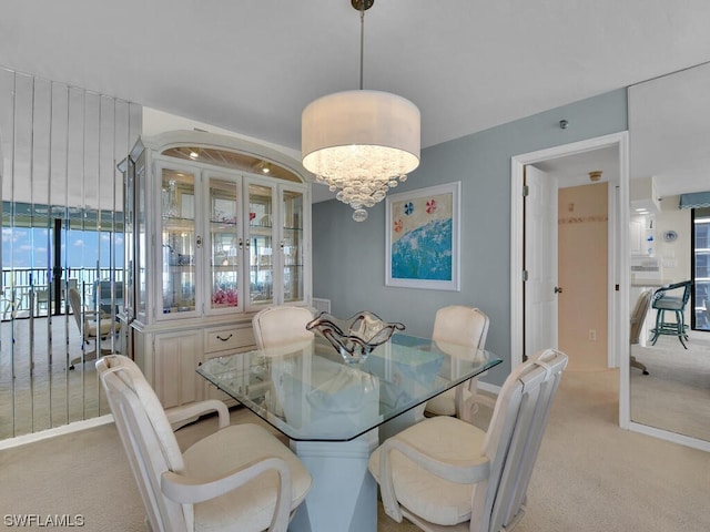 carpeted dining area with a notable chandelier