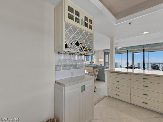 kitchen featuring white cabinetry, light tile flooring, and ceiling fan