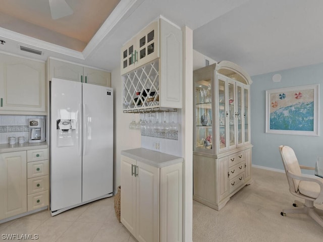 kitchen featuring a tray ceiling, refrigerator, backsplash, and ceiling fan