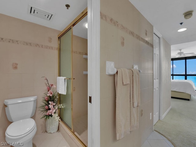 bathroom with ceiling fan, tile walls, tile flooring, toilet, and a shower with shower door