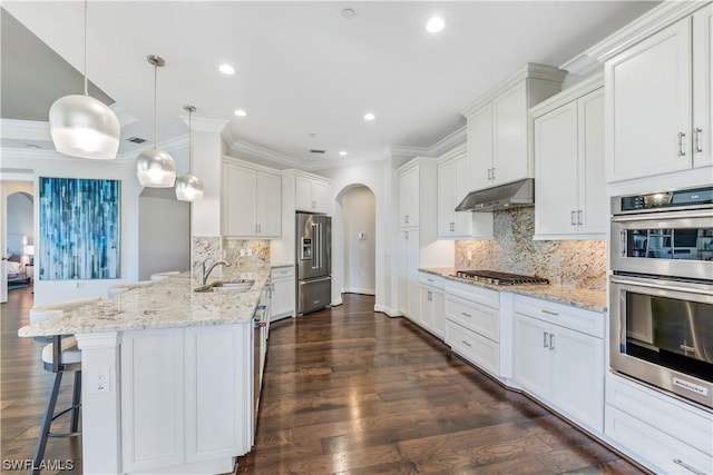 kitchen with stainless steel appliances, hanging light fixtures, and white cabinets