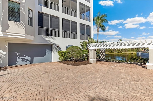 exterior space with a garage and a water view