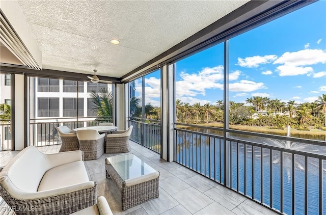 sunroom / solarium featuring a water view