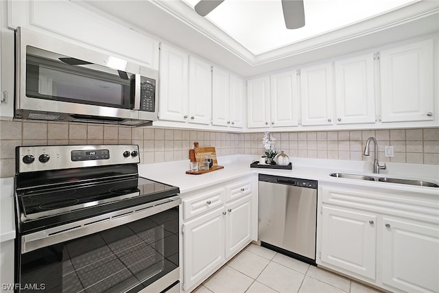 kitchen with sink, white cabinets, stainless steel appliances, and light tile patterned floors