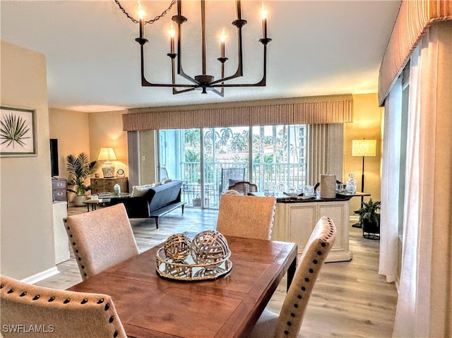 dining area with a notable chandelier and light wood-type flooring