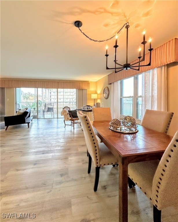 dining space featuring light hardwood / wood-style floors and an inviting chandelier