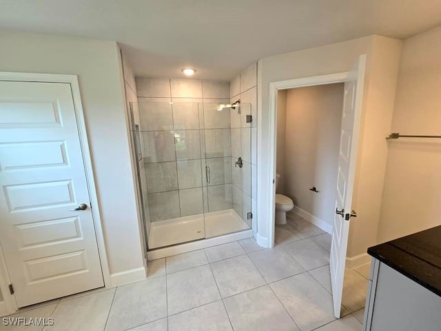 bathroom with vanity, tile patterned floors, toilet, and walk in shower