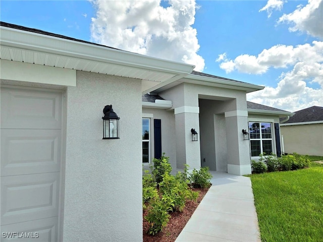 doorway to property featuring a yard and a garage