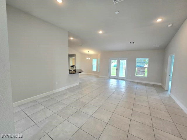 spare room featuring light tile patterned flooring and vaulted ceiling