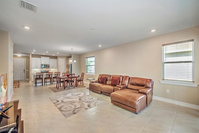 tiled living room featuring a notable chandelier