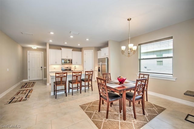 tiled dining area featuring sink and a chandelier