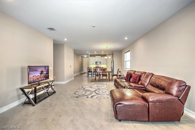 living room featuring light tile floors and a chandelier