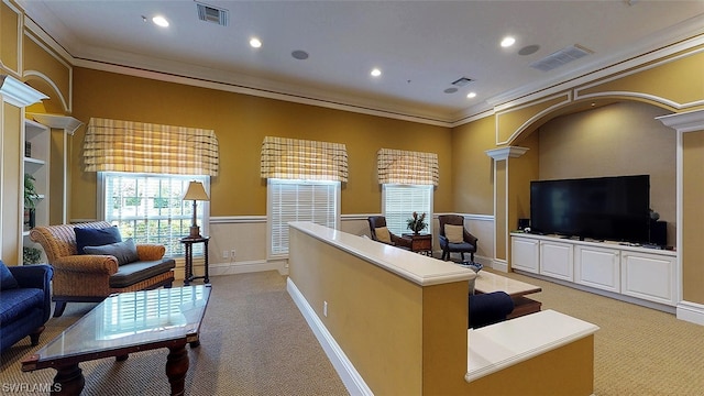 carpeted living room featuring crown molding and ornate columns