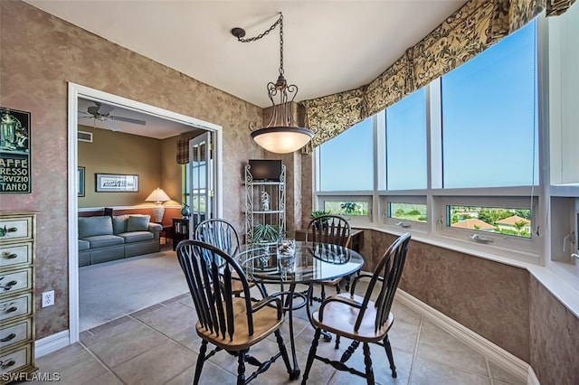 carpeted dining room with ceiling fan