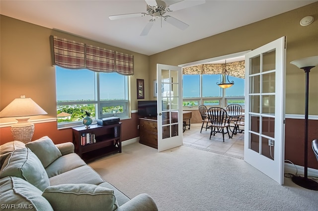 living room featuring light carpet, ceiling fan, and french doors