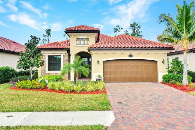 mediterranean / spanish house featuring a garage and a front yard