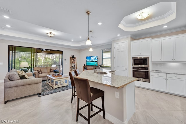 kitchen with a raised ceiling, white cabinetry, and stainless steel oven