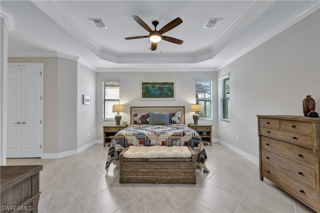 bedroom featuring ceiling fan, light tile patterned floors, and a tray ceiling