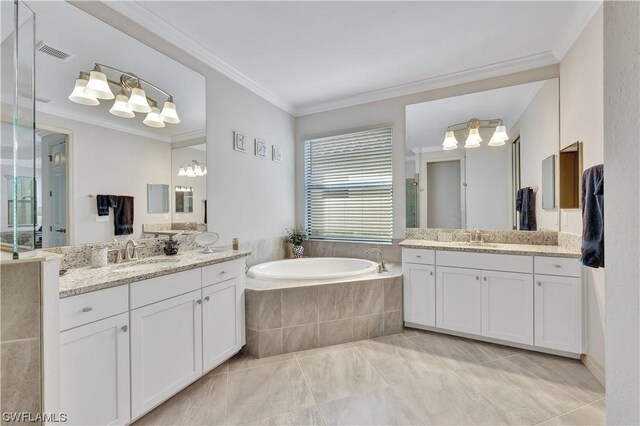 bathroom with tile patterned floors, crown molding, vanity, and a relaxing tiled tub