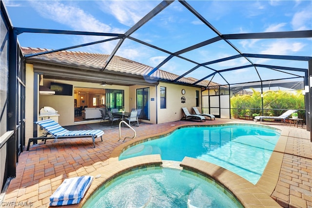 view of pool with a lanai, a patio area, and an in ground hot tub