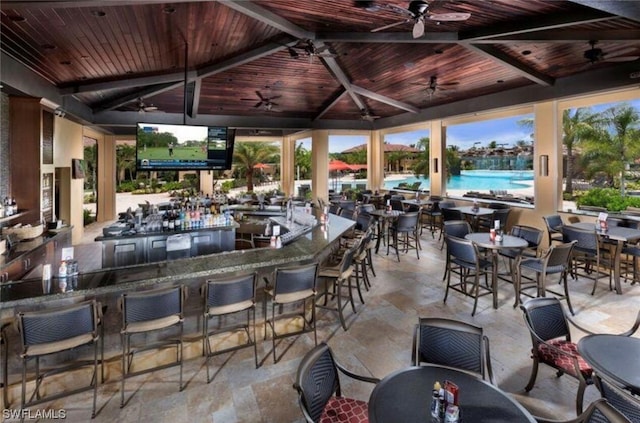 view of patio featuring a gazebo, ceiling fan, and an outdoor bar