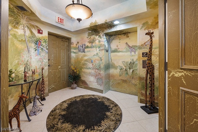 interior space with tile patterned floors and a raised ceiling