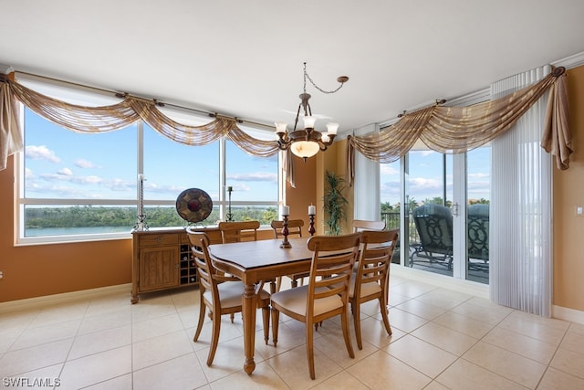 dining area featuring a chandelier, light tile patterned floors, and a water view