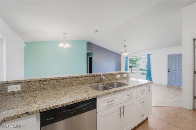 kitchen with lofted ceiling, sink, stainless steel dishwasher, light stone countertops, and white cabinetry