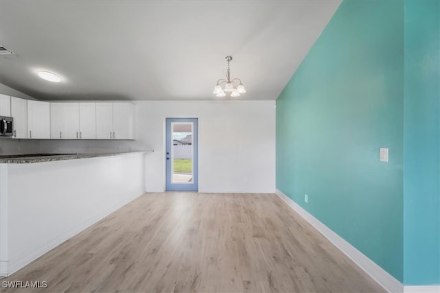 interior space with a chandelier and light wood-type flooring