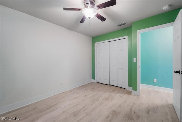 unfurnished bedroom with a closet, light hardwood / wood-style floors, and ceiling fan