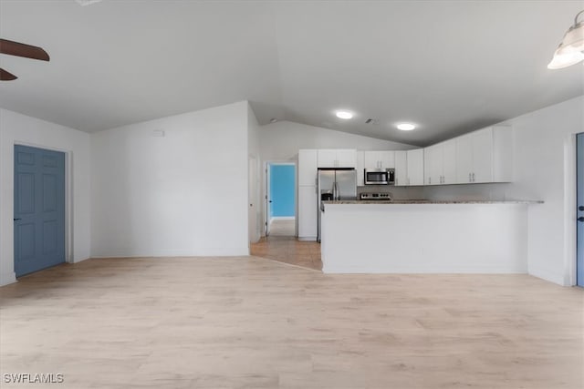 kitchen featuring white cabinetry, stainless steel appliances, light hardwood / wood-style flooring, kitchen peninsula, and lofted ceiling