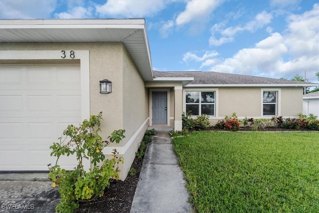 property entrance with a garage and a lawn